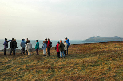 Picture of walkers standing on a cliff in the evening sun