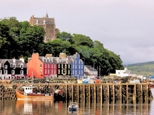Picture of red, yellow and blue houses in Tobermory with the yellow house painted over in black